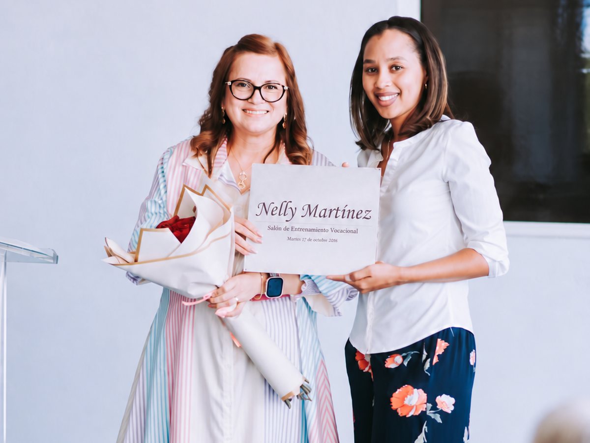 Dos mujeres sostienen un reconocimiento a nombre de Nelly Martínez